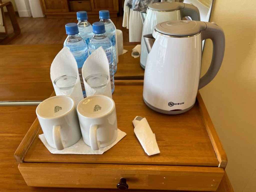 アメニティの水ボトル、湯沸かし器、カップ