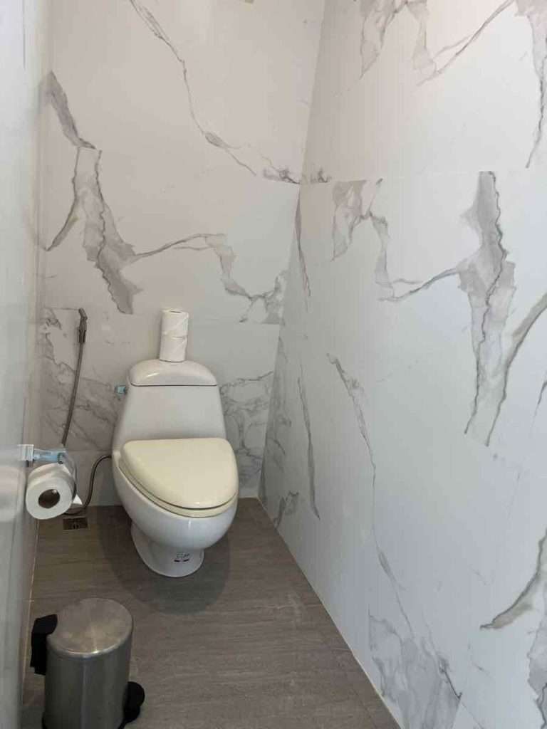白い大理石の壁のトイレ