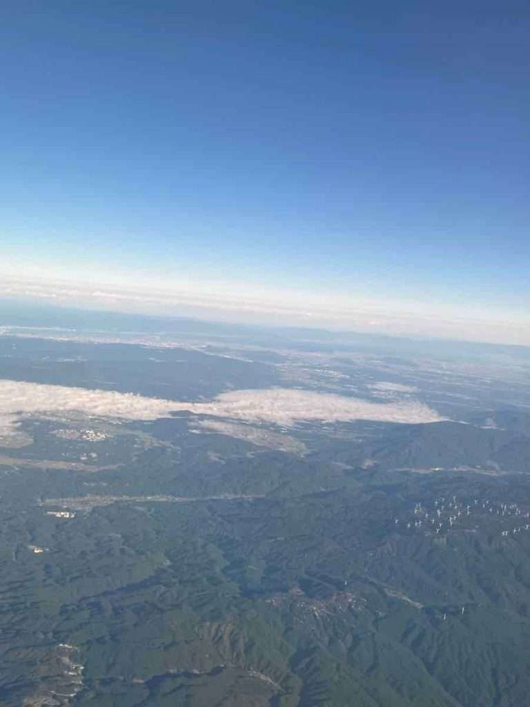 飛行機の上から見る山脈と青い空