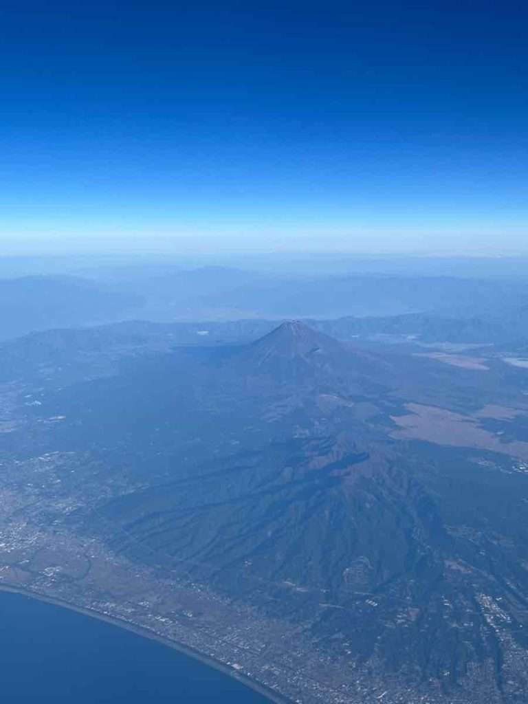飛行機の窓から見下ろした雲ひとつ無い富士山