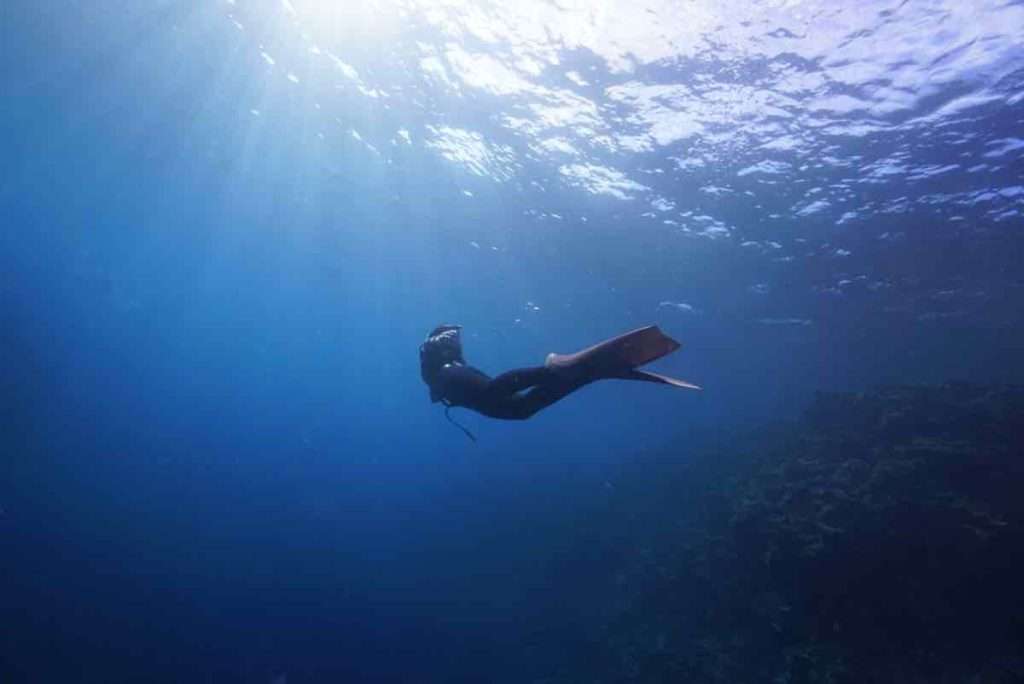 宮古島の青い海と潜る女性