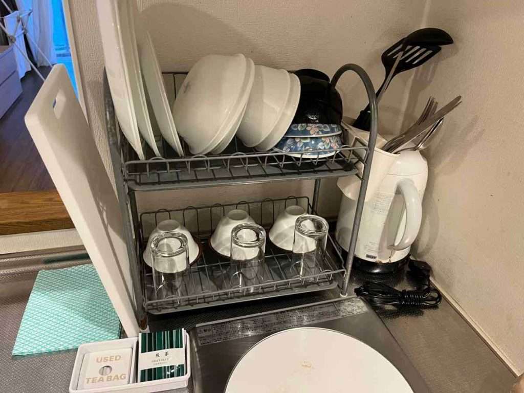 皿が数枚と湯呑とグラスの置かれた食器棚