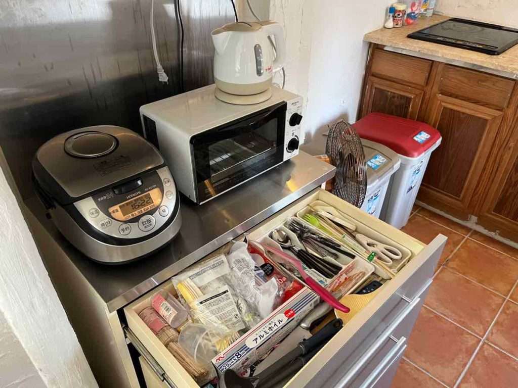 調理器具が格納された引き出しと、棚に設置された炊飯器や湯沸かしポッドとトースター