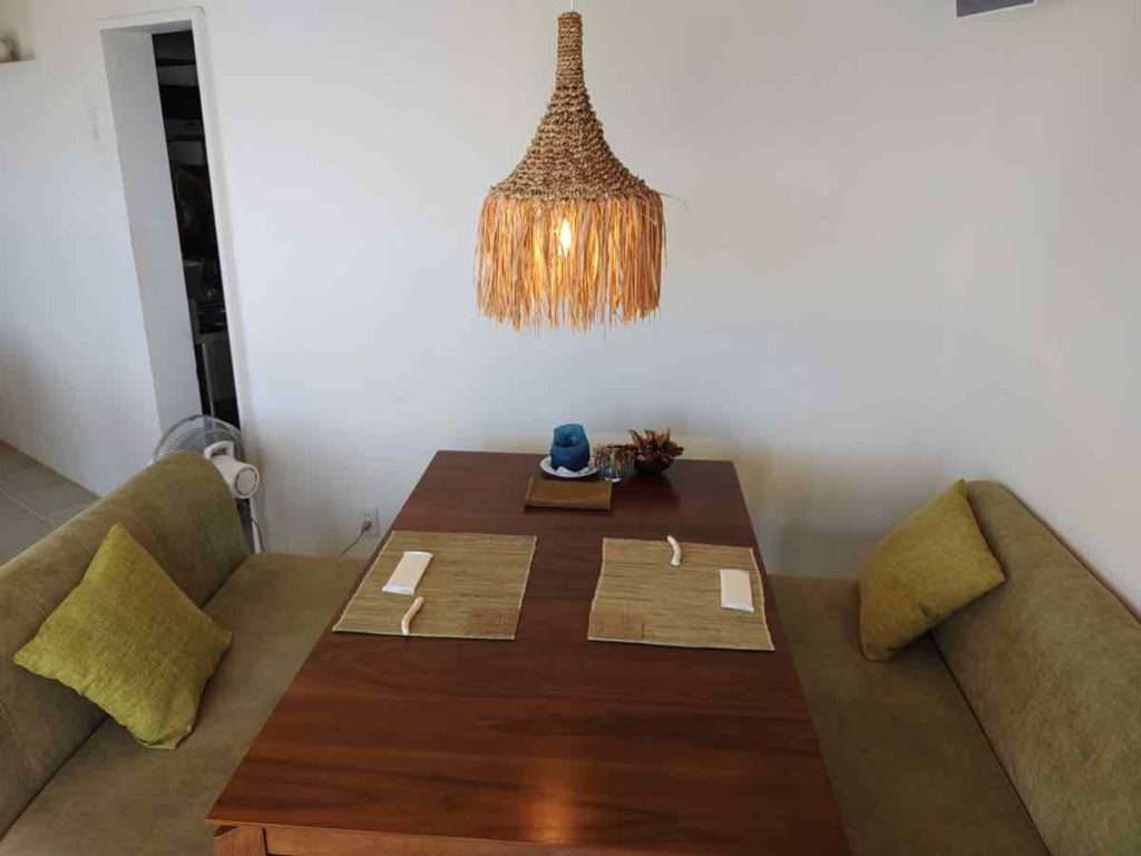 うぐいす色のソファと重厚な木のテーブルの上にランチョンマットと箸置きが置かれている
