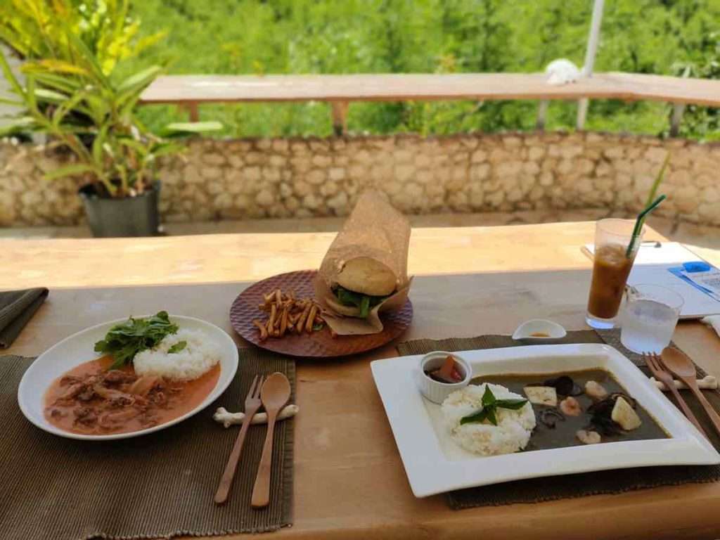 テーブルの上のハヤシライスと宮古牛ハンバーガーと島野菜のグリーンカレー