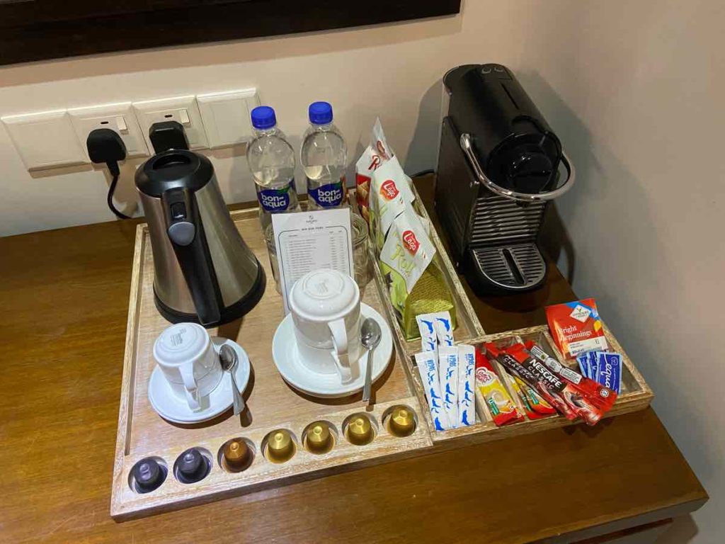 机とその上に置かれたコーヒーメーカーと水ボトル、有料のスナック