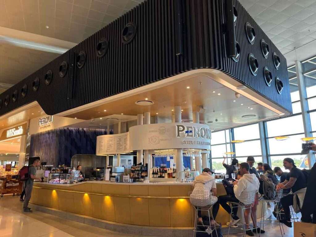 空港内ガラス窓の隣にある明るいレストランバー「ペリオニ」