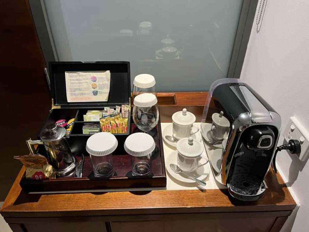 コーヒーと紅茶とグラスの並んだ客室のミニバー