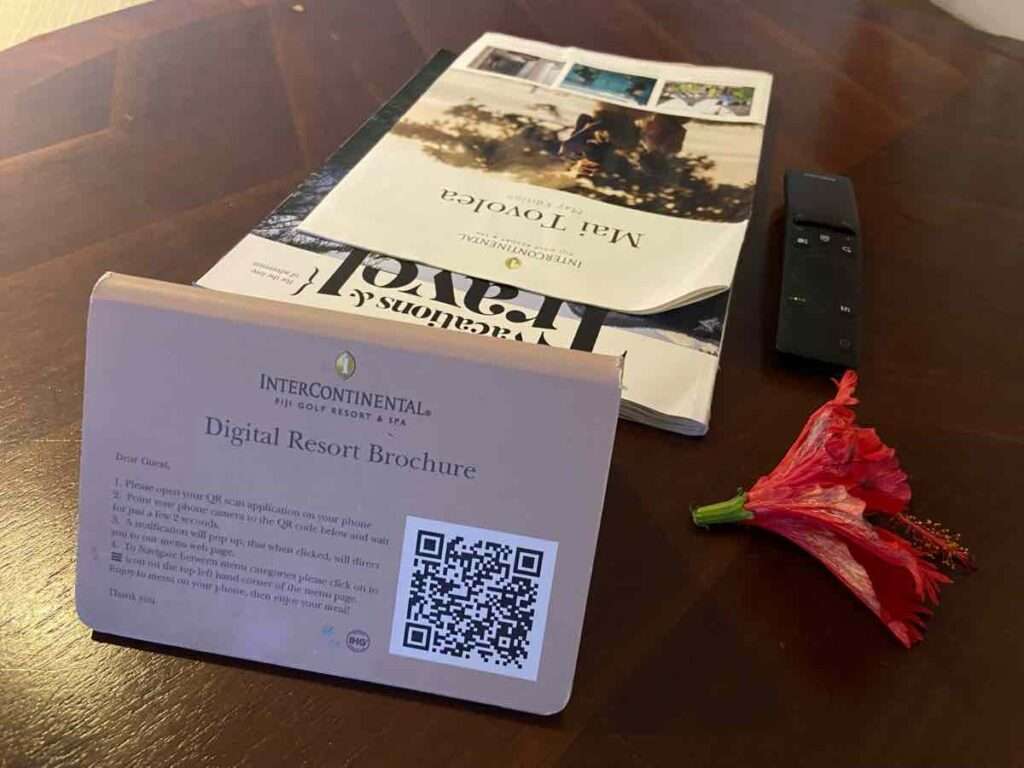 テーブルに置かれた花とホテルパンフレットのバーコード