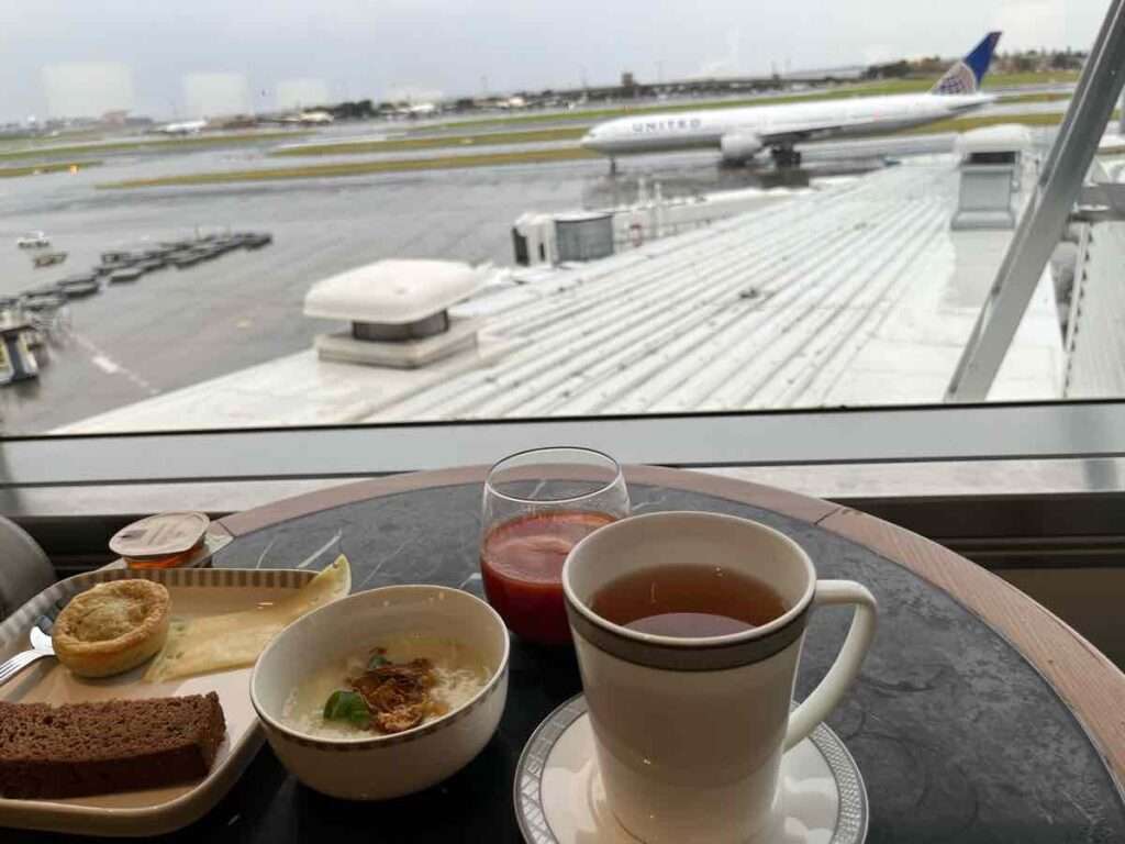 コーヒーやパイの置かれたテーブル。飛行機を窓に見ながらの朝食