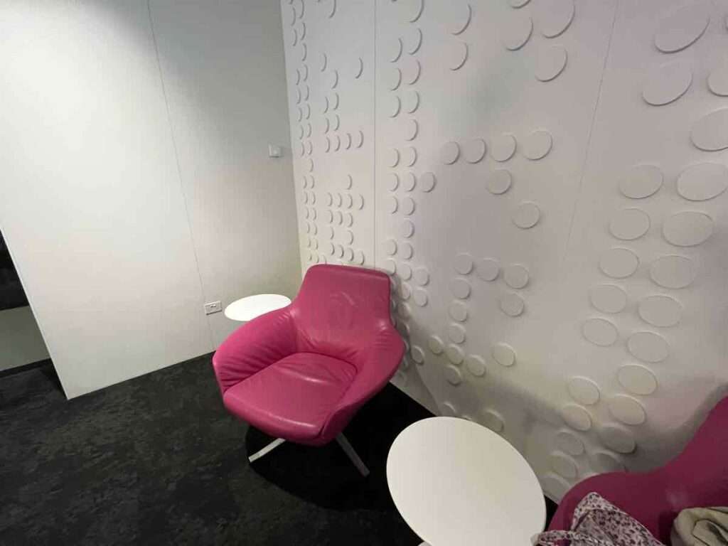 スタイリッシュなデザインの白い壁とピンクのソファ