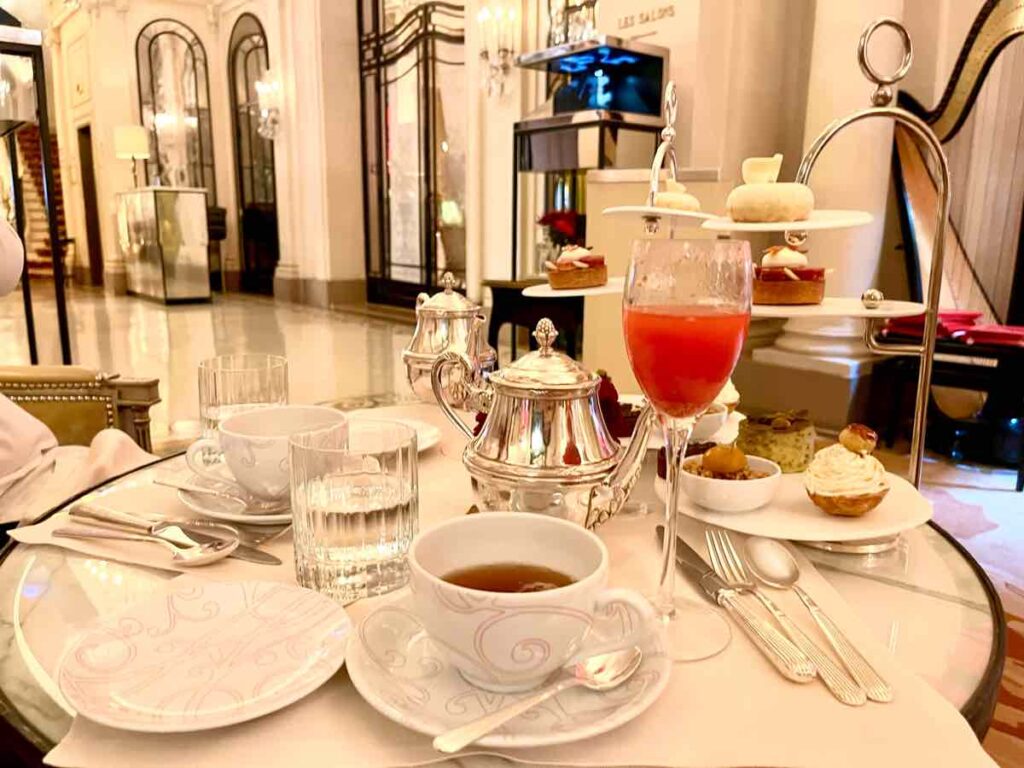 テーブルに置かれているシャンパングラスに注がれたベリーのカクテルや紅茶や銀のティーポッド