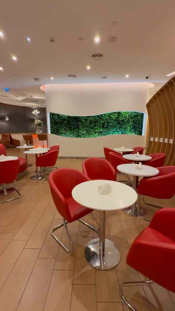 スカイチームラウンジの白い壁に赤い美しいソファが並んでいる。