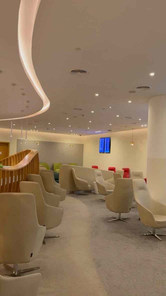 スカイチームラウンジのオフホワイトの綺麗な壁とベージュのサファが並んでいる